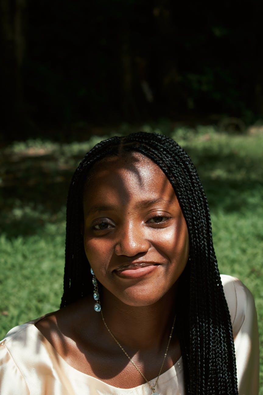 Smiling woman stretching outdoors in a green park.