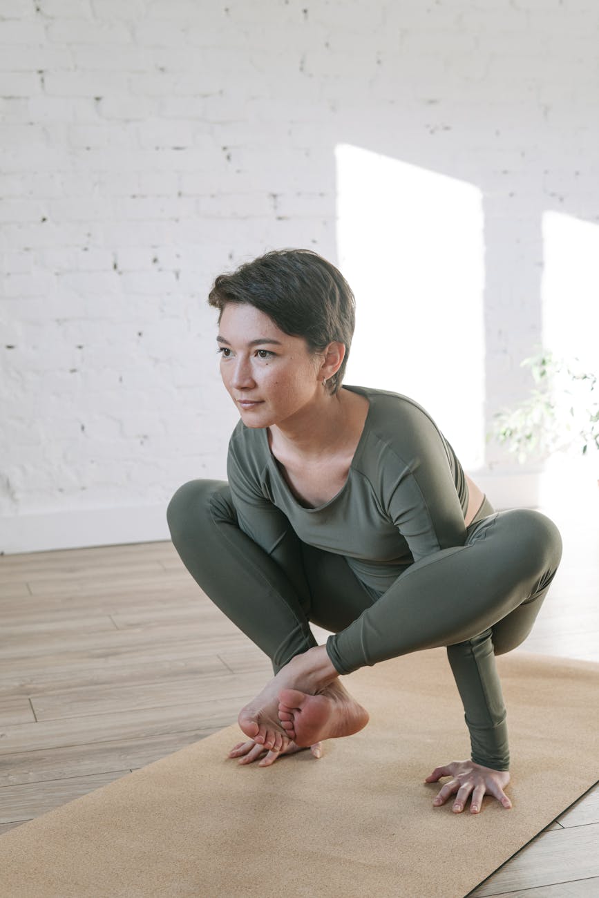 Woman in a calm yoga pose in a bright, peaceful room.